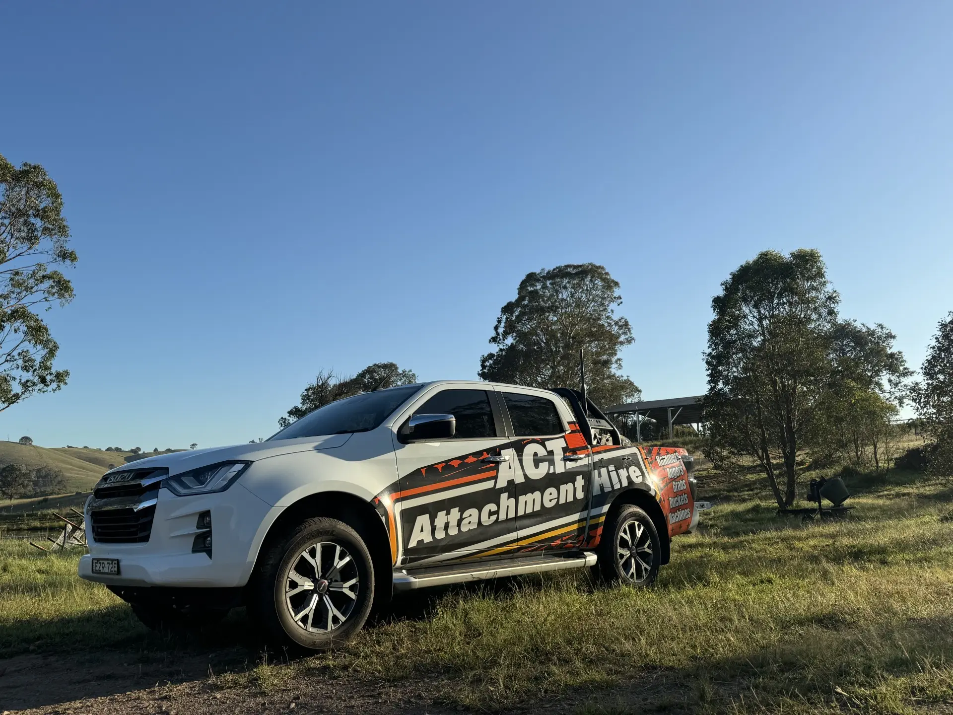 ACT Attachment Hire branded ute parked in a rural paddock near Queanbeyan