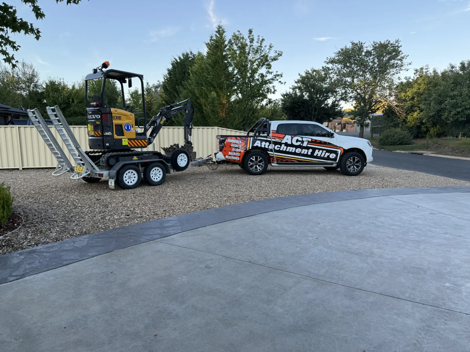 Mini excavator on a trailer behind a branded ACT Attachment Hire ute