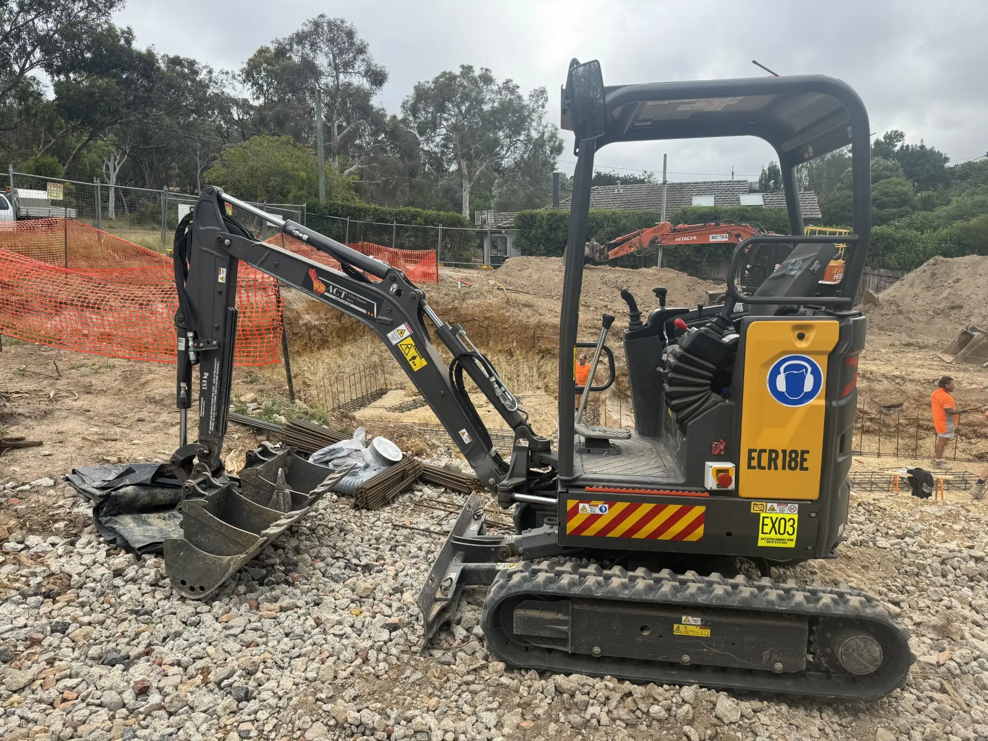 Black mini excavator working on a gravel site